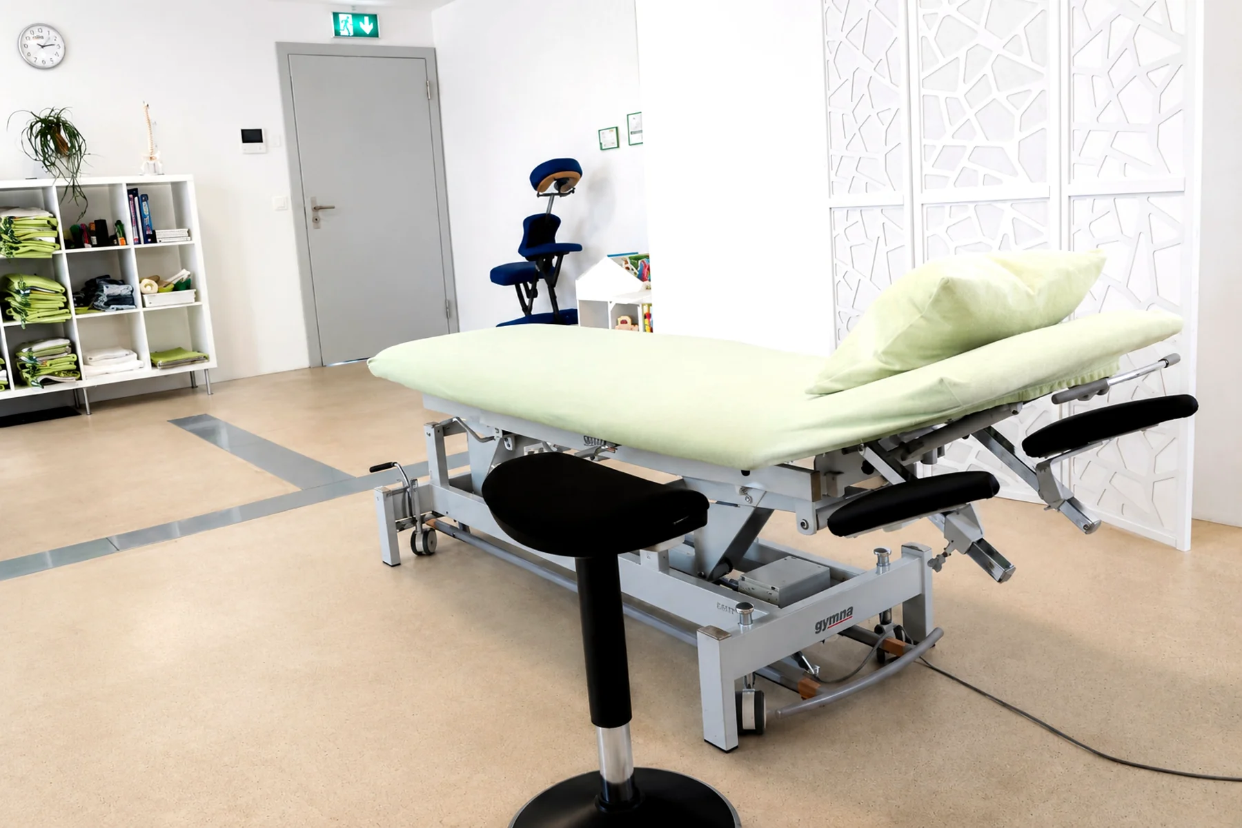 Heller MEDOS-Behandlungsbereich mit Therapieliege und Sichtschutz.