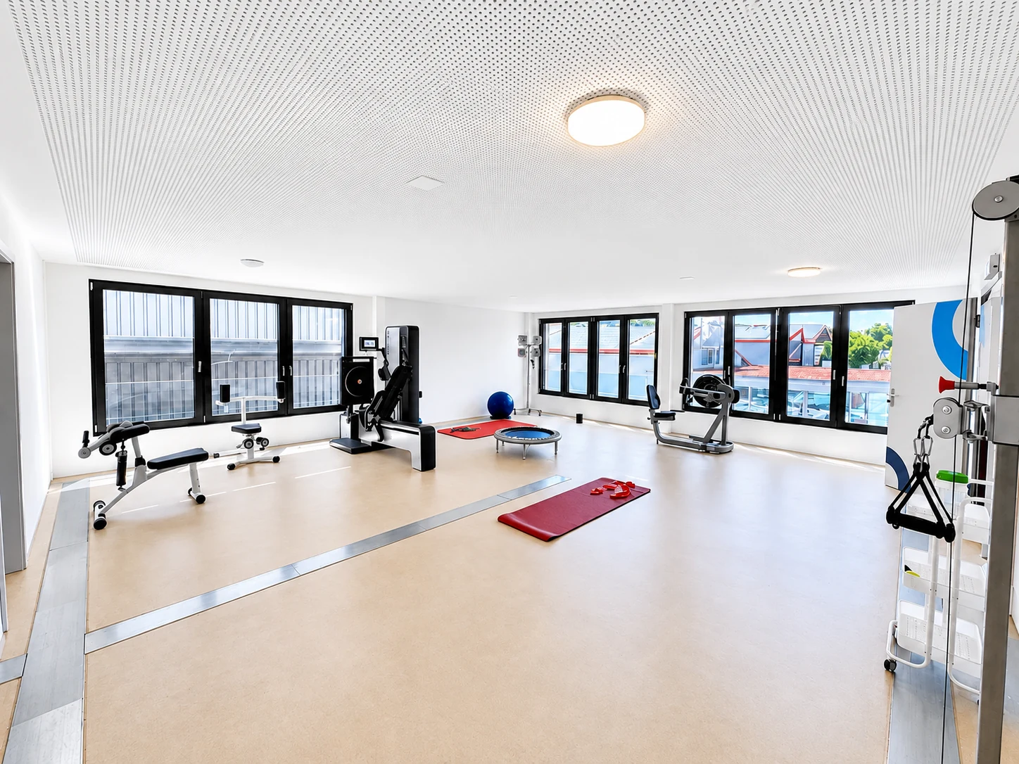 Grosszügiger MEDOS-Trainingsraum mit Geräten, Matten und Trampolin